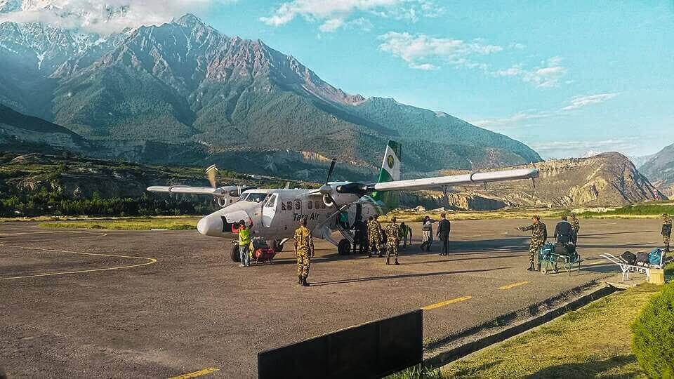 jomsom airport military personal loading bags into plane