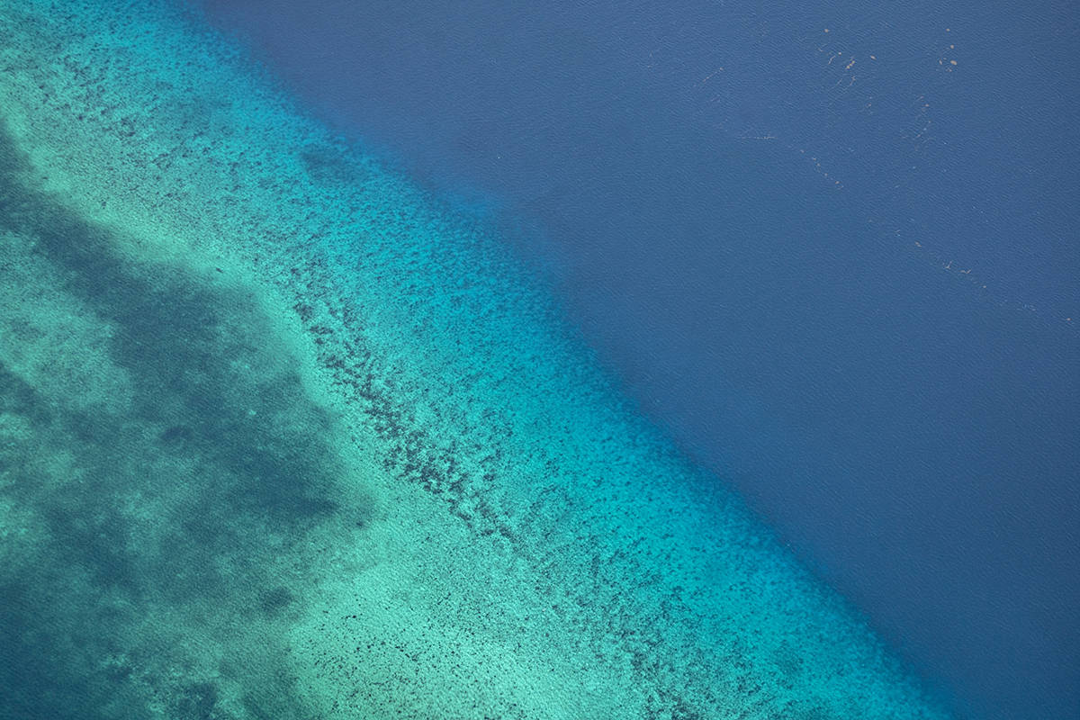different contrast of water depending on the depth looking out the window when flying roatan to belize