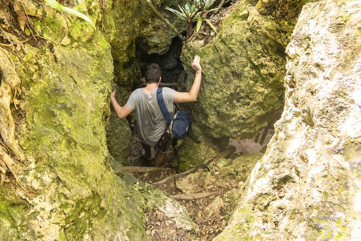 squeezing through the rocks to the entrance of the cave in lifou
