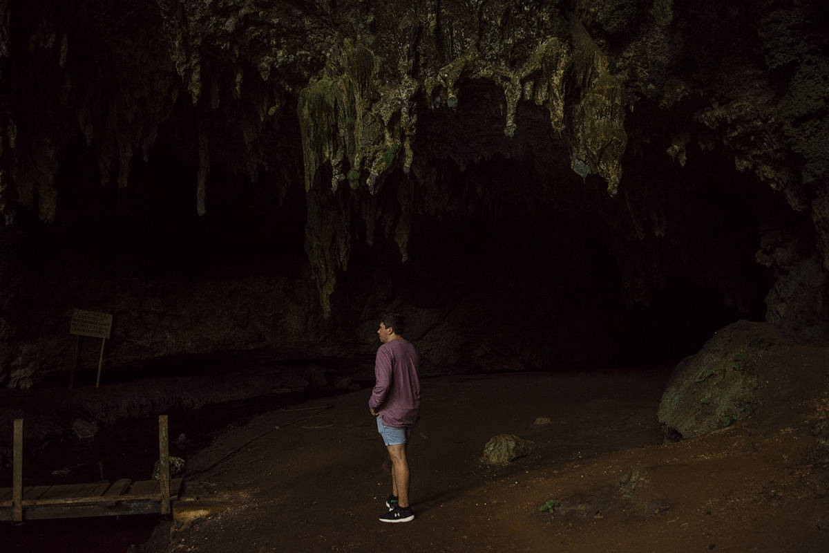 Visiting Queen Hortense's Cave In Isle Of Pines 35 A man standing in front of Queen Hortense’s Cave on the Isle Of Pines.