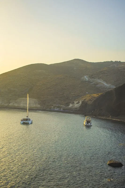 22 Cheapest Countries To Backpack & Travel On A Budget 26 A group of sailboats in the water near a hill in santorini