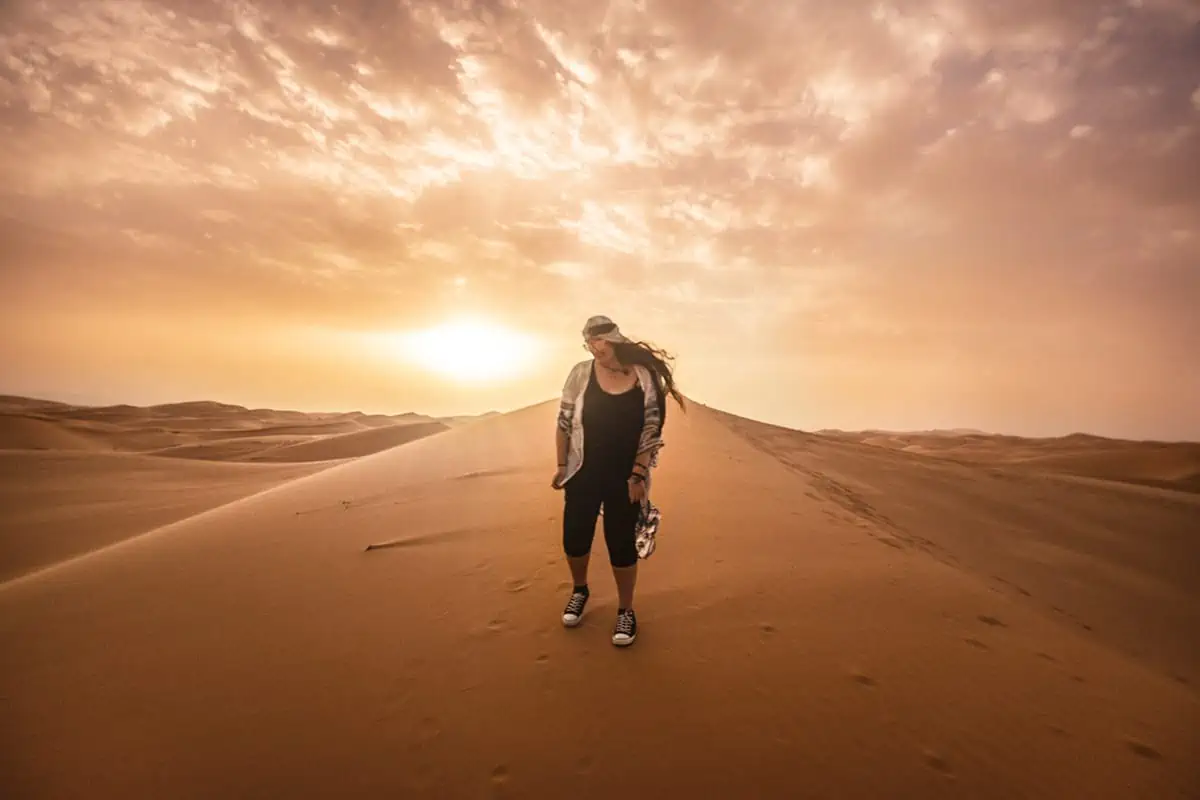 22 Cheapest Countries To Backpack & Travel On A Budget 2 tasha amy standing on a sand dune at sunset in morocco