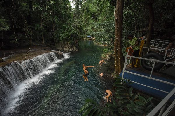 people jumping off the platform into the water at rarru cascades in port vila