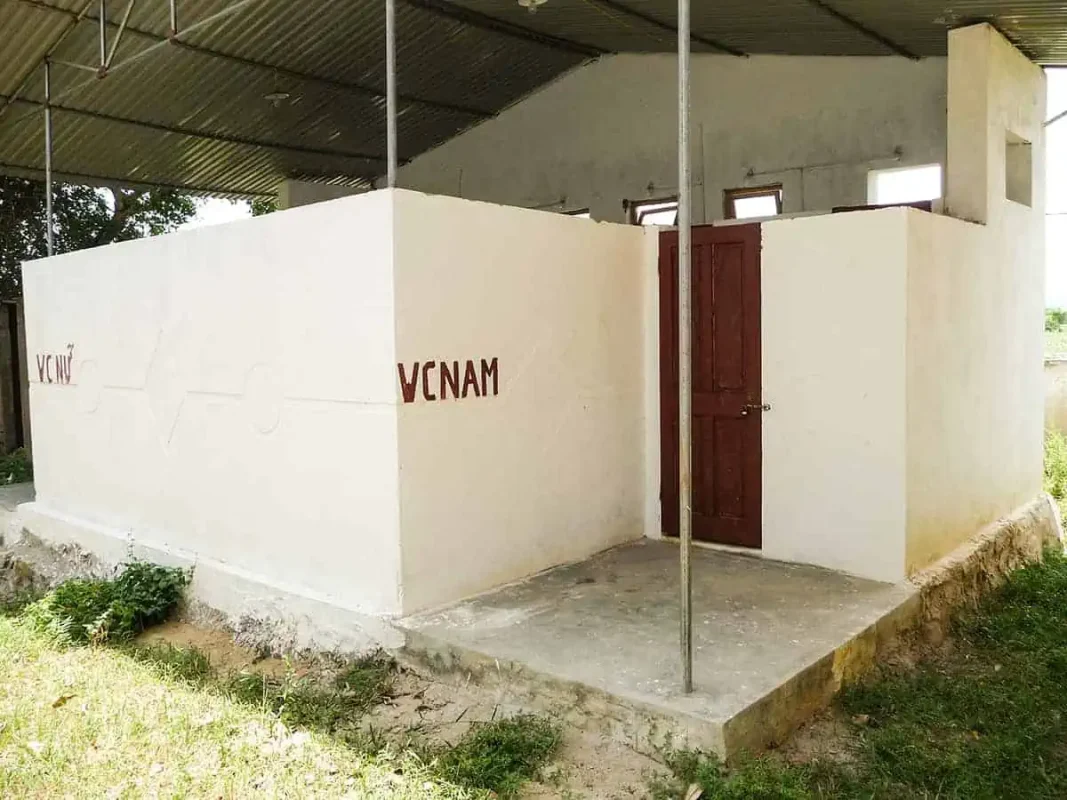 A Vietnam Sleeper Bus stop facility with 'VIETNAM' painted on the exterior, offering basic amenities on a typical VIP sleeper bus journey in Vietnam.