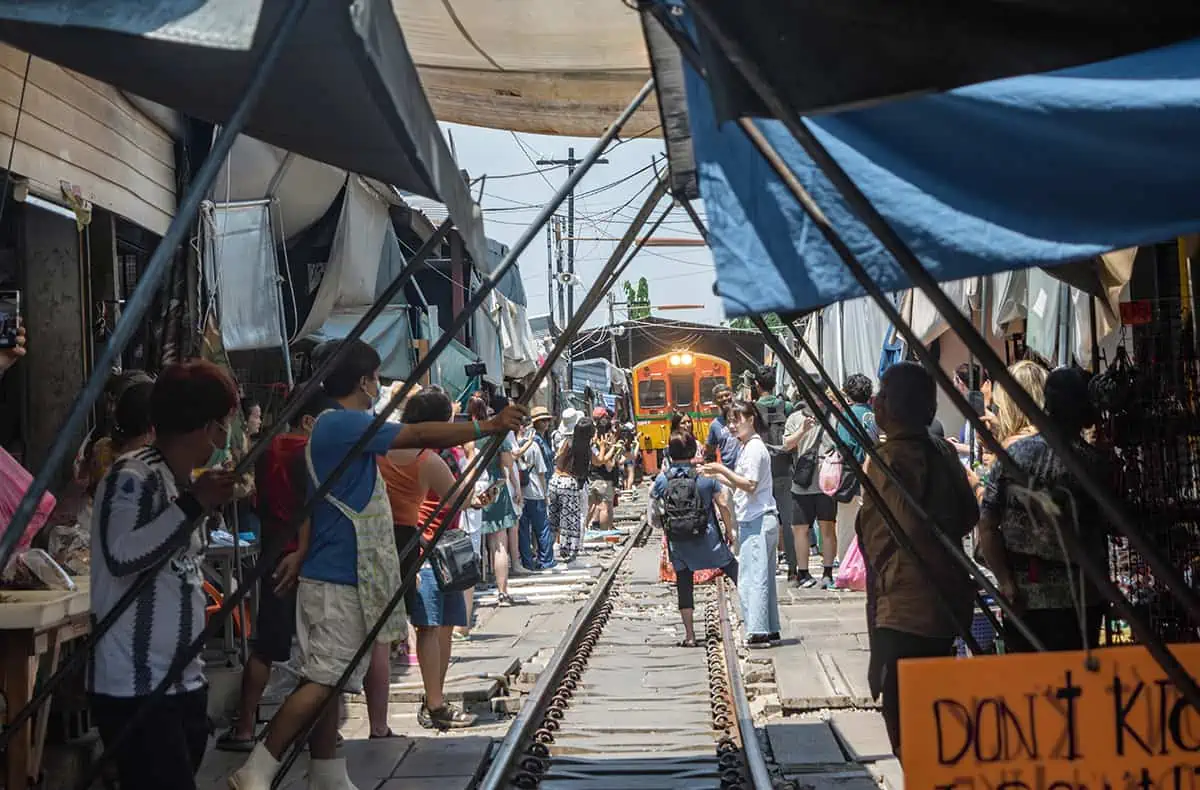 2 Days In Bangkok Itinerary: How To Spend The Ultimate 48 Hours In Bangkok 27 watching the train come through the maeklong railway market with sellers about to pull back the awnings