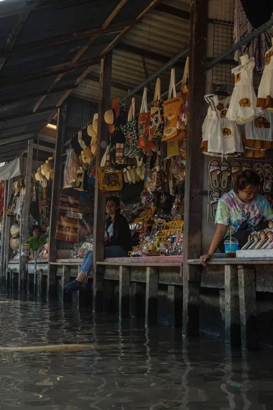 sellers in stalls over the water which your boat will visit on a floating market tour while on your bangkok itinerary