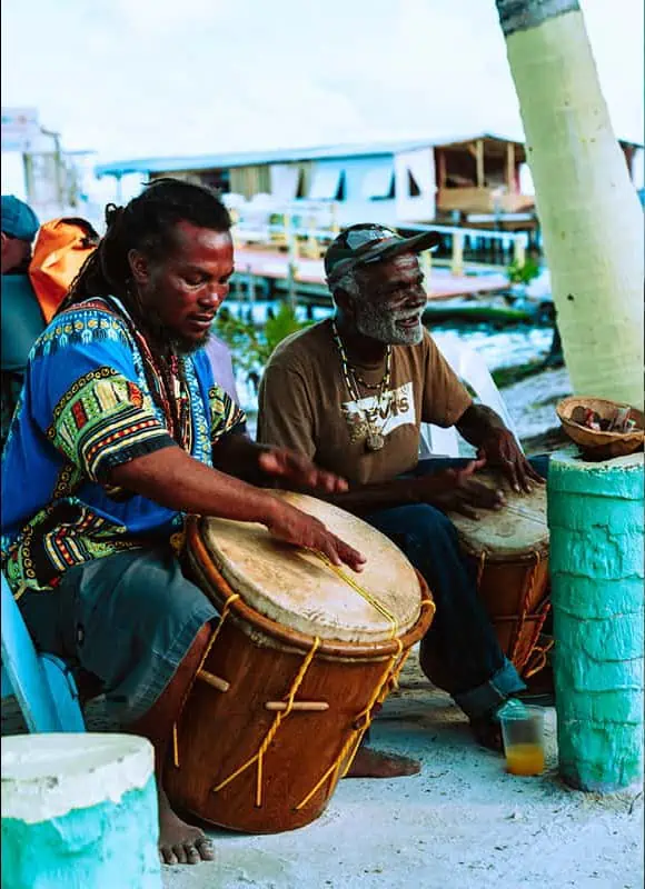 a couple of locals playing music in caye caulker