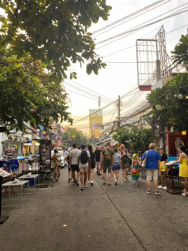 walking down a busy khao san road during sunset in bangkok