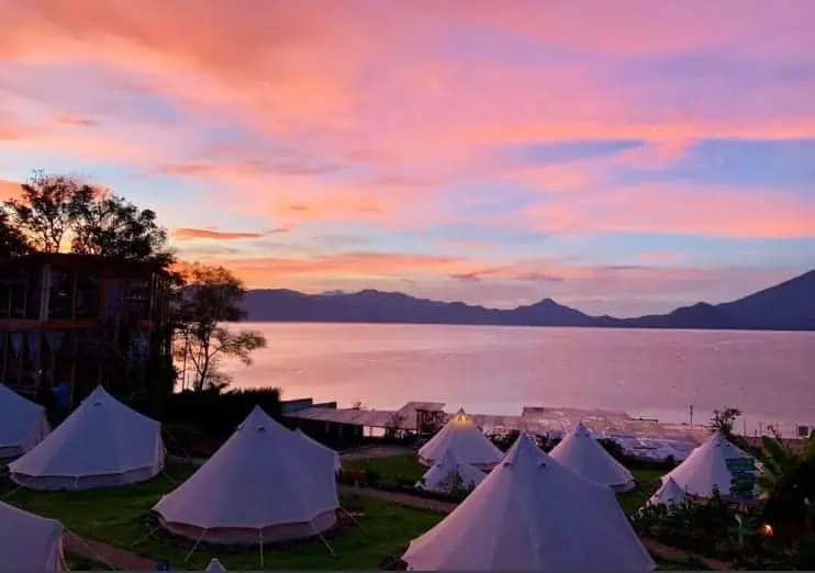 Best Hostels In Lake Atitlan: My Favorites Around The Lake 27 enjoying sunset over the glamping tents which are the shared dorms at free cerveza hostel in lake atitlan