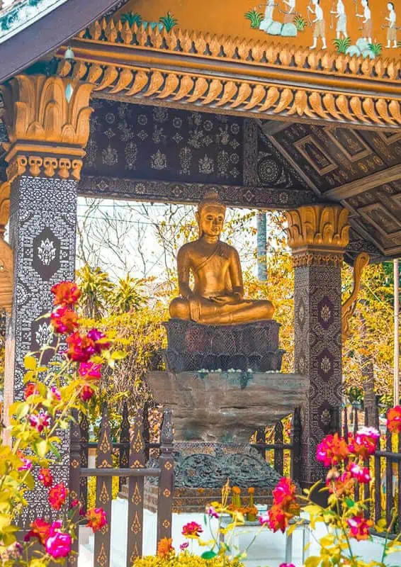buddha underneath a pavilion at one of the incredible temples worth visiting on your luang prabang itinerary