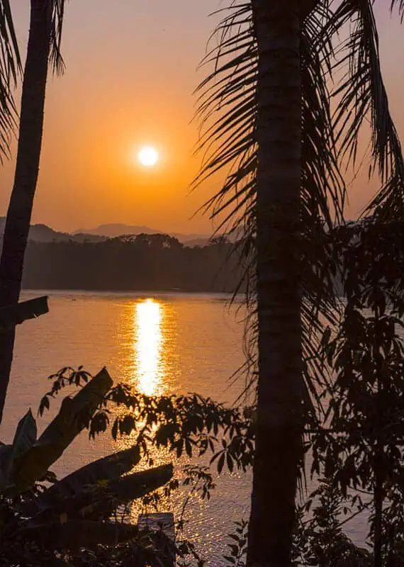 sunset through the trees over the mekong river, the ideal way to spend an evening on the 3 days in luang prabang itinerary