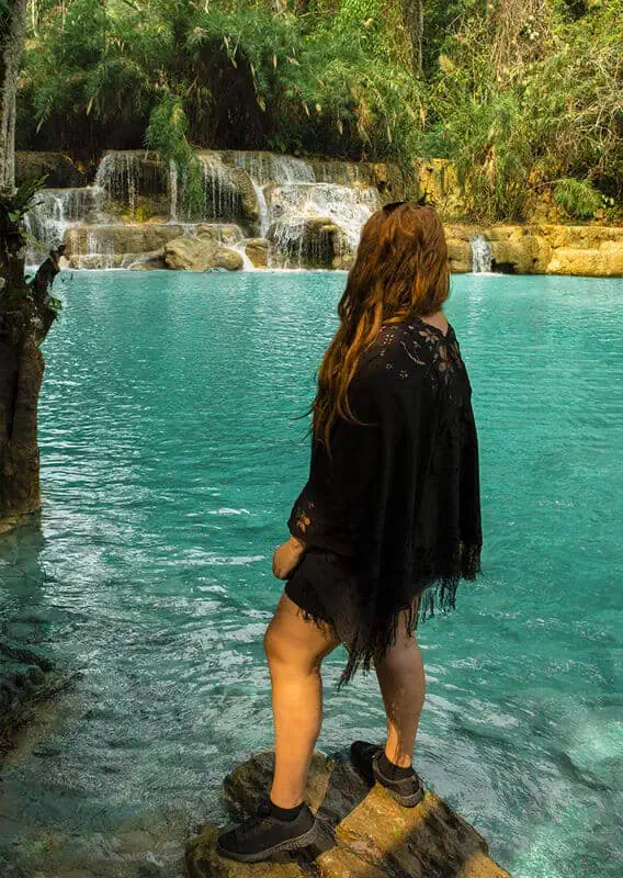 admiring the cascades of blue water at kuang si falls