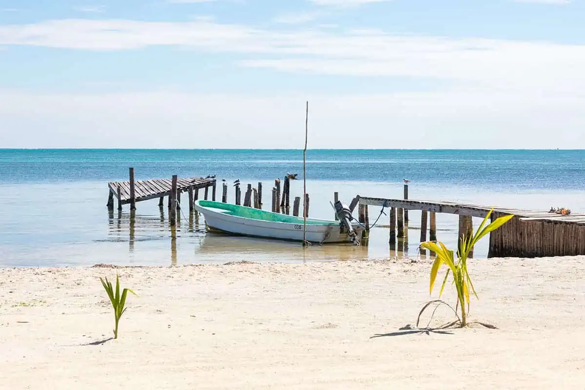 a lone boat tied to a small pier in caye caulker belize