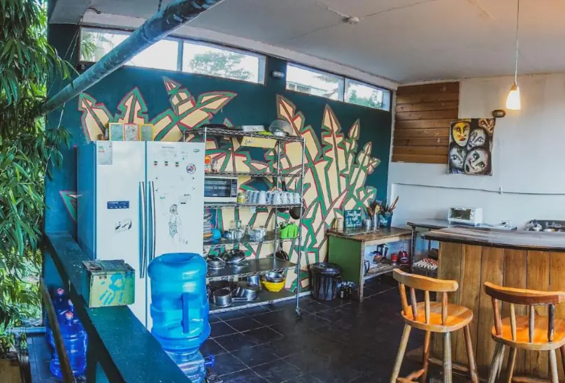 Best Hostels In San Ignacio: 5 Excellent Stays For Travelers On A Budget 63 A communal kitchen area inside Bella's Backpackers, adorned with colorful murals and fully equipped for guest use, illustrating the convenient facilities at this top-rated San Ignacio hostel.