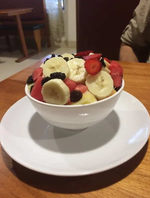 12 Best Restaurants In San Ignacio: Top Eats For Visitors 55 A healthy bowl of fresh fruit salad with banana, strawberry, and raisins, a light and nutritious option when wondering where to eat in san ignacio