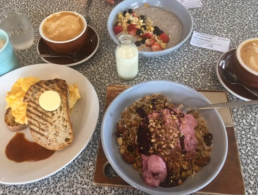 12 Best Restaurants In San Ignacio: Top Eats For Visitors 56 A hearty breakfast spread with scrambled eggs on toast, oatmeal with fruit, and a cappuccino, typical of the morning offerings at the shack cafe, one of best restaurants in San Ignacio.