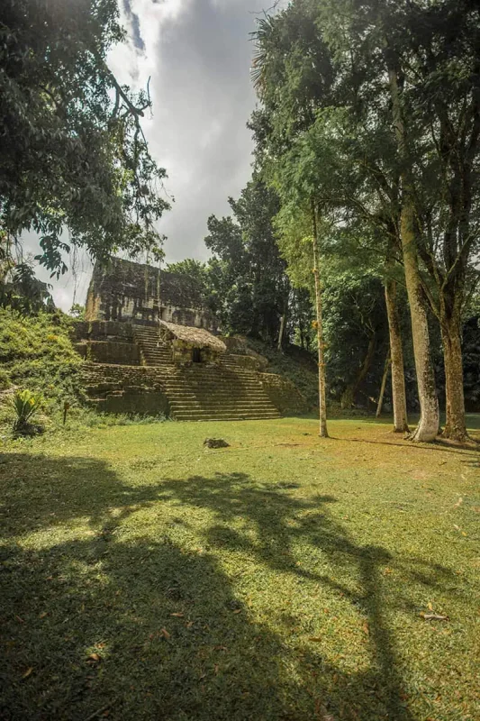 San Ignacio To Tikal & BEST Tikal Tours From San Ignacio 63 A secluded ancient structure at Tikal enveloped in the jungle ambiance, captured during a serene moment on a tour from San Ignacio.