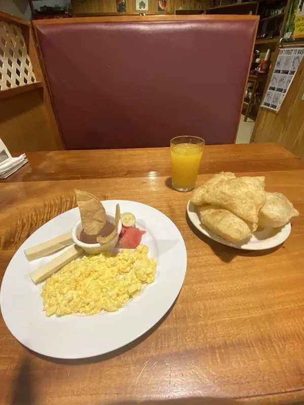 San Ignacio To Tikal & BEST Tikal Tours From San Ignacio 60 Local Belizean breakfast consisting of scrambled eggs, fry jacks, and fresh juice, fueling up before a Tikal tour from San Ignacio.