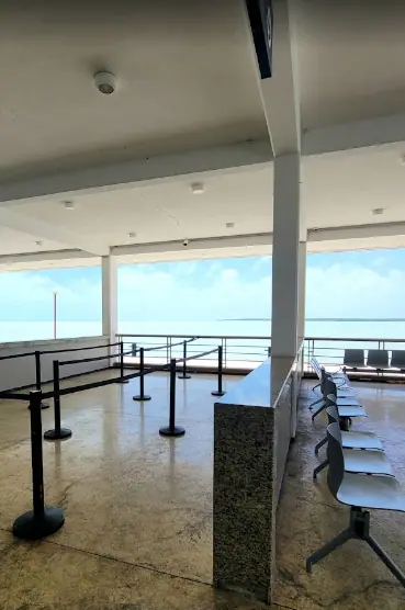 Bacalar To Caye Caulker: The ULTIMATE Travel Guide 2026 57 An empty waiting area at a ferry terminal in Chetumal, with stanchions guiding passengers and metal chairs arranged in rows.