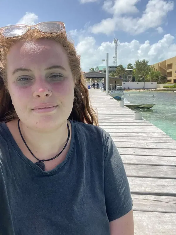 Bacalar To Caye Caulker: The ULTIMATE Travel Guide 2026 64 Selfie of Tasha Amy with red hair sitting on a wooden dock.
