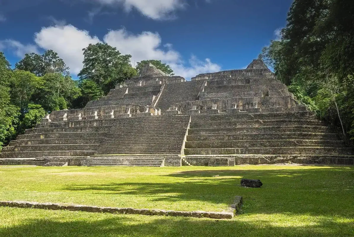 Best Things To Do In San Ignacio: Caves, Ruins & Day Trips 68 The grand pyramid of Caracol, an impressive Mayan ruin in San Ignacio, Belize. The pyramid features multiple terraces and steep steps, with dense forest greenery providing a striking backdrop against a clear blue sky
