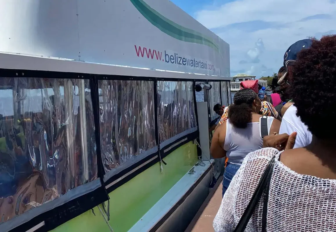 Chetumal To Caye Caulker: Best & Easiest Transport 2026 9 Passengers waiting in line to board the Belize Water Taxi ferry. The side of the ferry displays the website "www.belizewatertaxi.com" in bold letters. This vessel offers direct service from Chetumal to Caye Caulker, promising a scenic journey across the Caribbean Sea