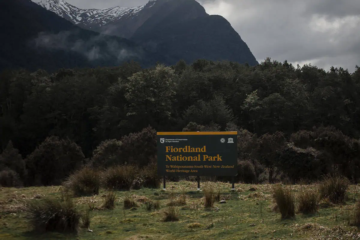Fiordland & Milford Sound Lord Of The Rings Locations (2026) 28 A dark green sign marks the entrance to Fiordland National Park in New Zealand, a Lord of the Rings filming location