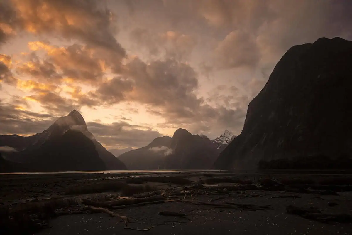 Is Milford Sound Worth It? My Pros & Cons 4 Sunset over Mitre Peak at Milford Sound, New Zealand, with clouds glowing orange and pink, answers the question is milford sound worth it