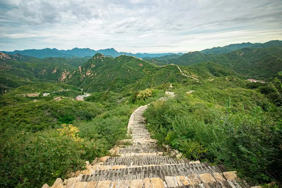 120+ Would You Rather Travel Questions For Ultimate Wanderers 2 A rugged section of the Great Wall of China stretches through green hills, with distant mountain peaks, this location should definitely be considered for the would you rather travel questions