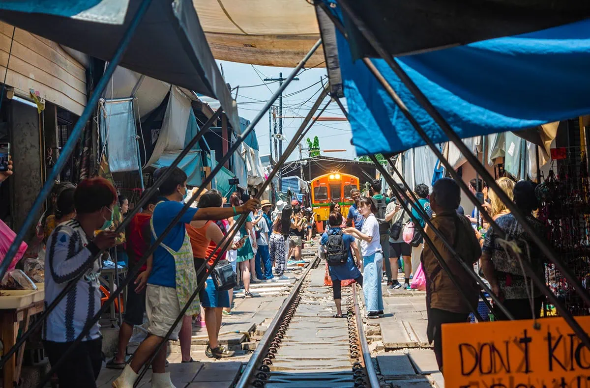 2 Days in Bangkok Itinerary For First-Time Visitors 56 watching the train come through the Maeklong Railway Market with sellers about to pull back the awnings