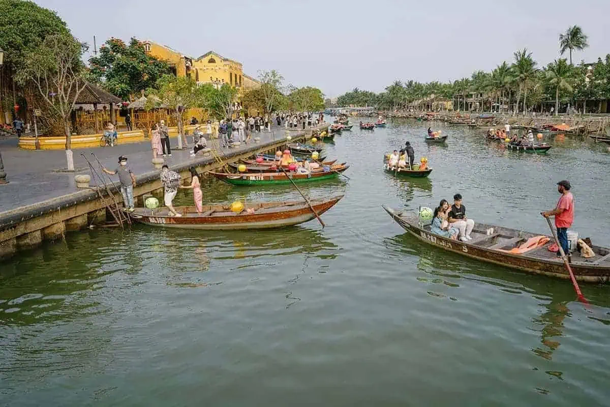 3 Weeks In Vietnam Itinerary: The Perfect First-Time Route 75 Looking out over the river in Hoi An with traditional boats and tourists going for rides