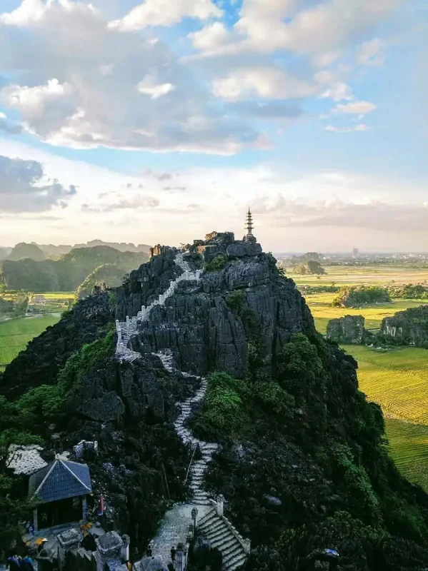 3 Weeks In Vietnam Itinerary: The Perfect First-Time Route 62 Looking over towards a staircase leading up a mountain to a pagoda in Ninh Binh