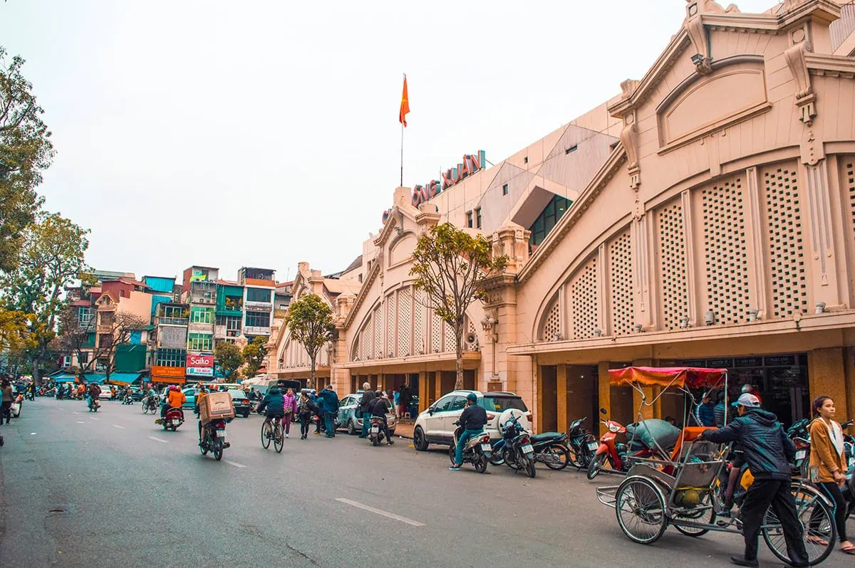 3 Weeks In Vietnam Itinerary: The Perfect First-Time Route 45 Busy street scene outside Dong Xuan Market in Hanoi with motorbikes and vendors