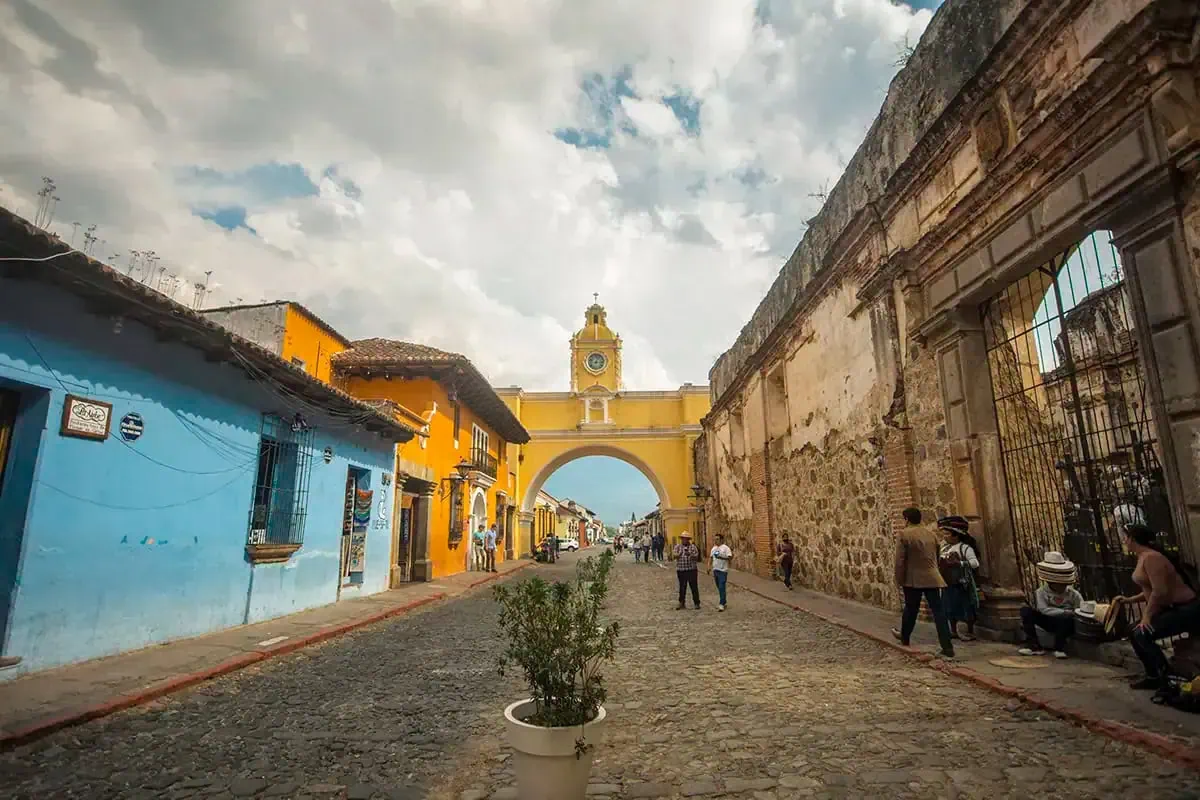 the famous Arco de Santa Catalina in Antigua with tourists walking down the street