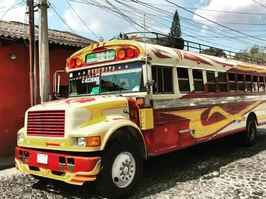 a colorful chicken bus in the street driving from Antigua to Lake Atitlan