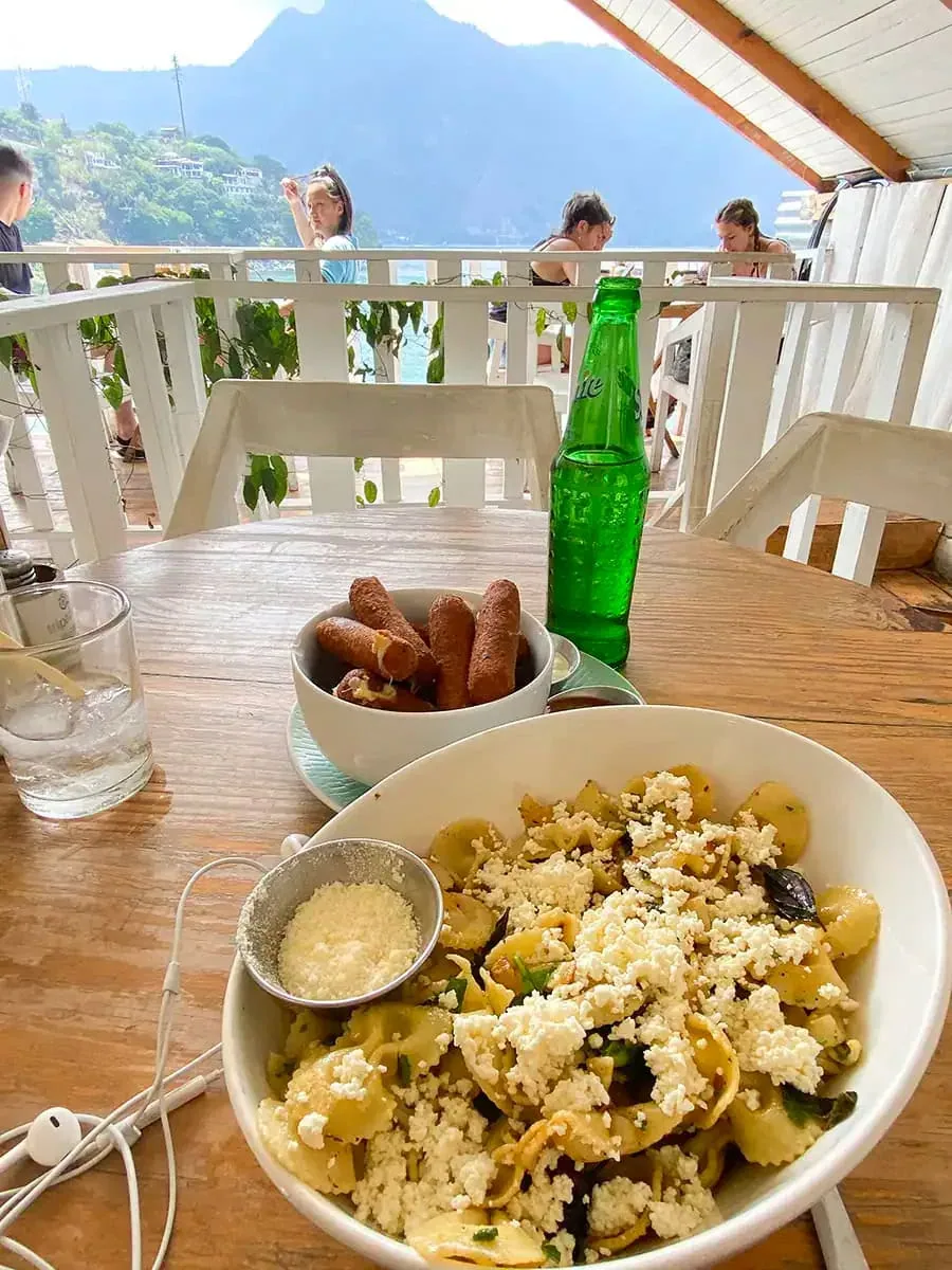 a bowl of pasta with feta and sundried tomatoes on a table at Sababa Restaurant in San Pedro La Laguna, Lake Atitlan