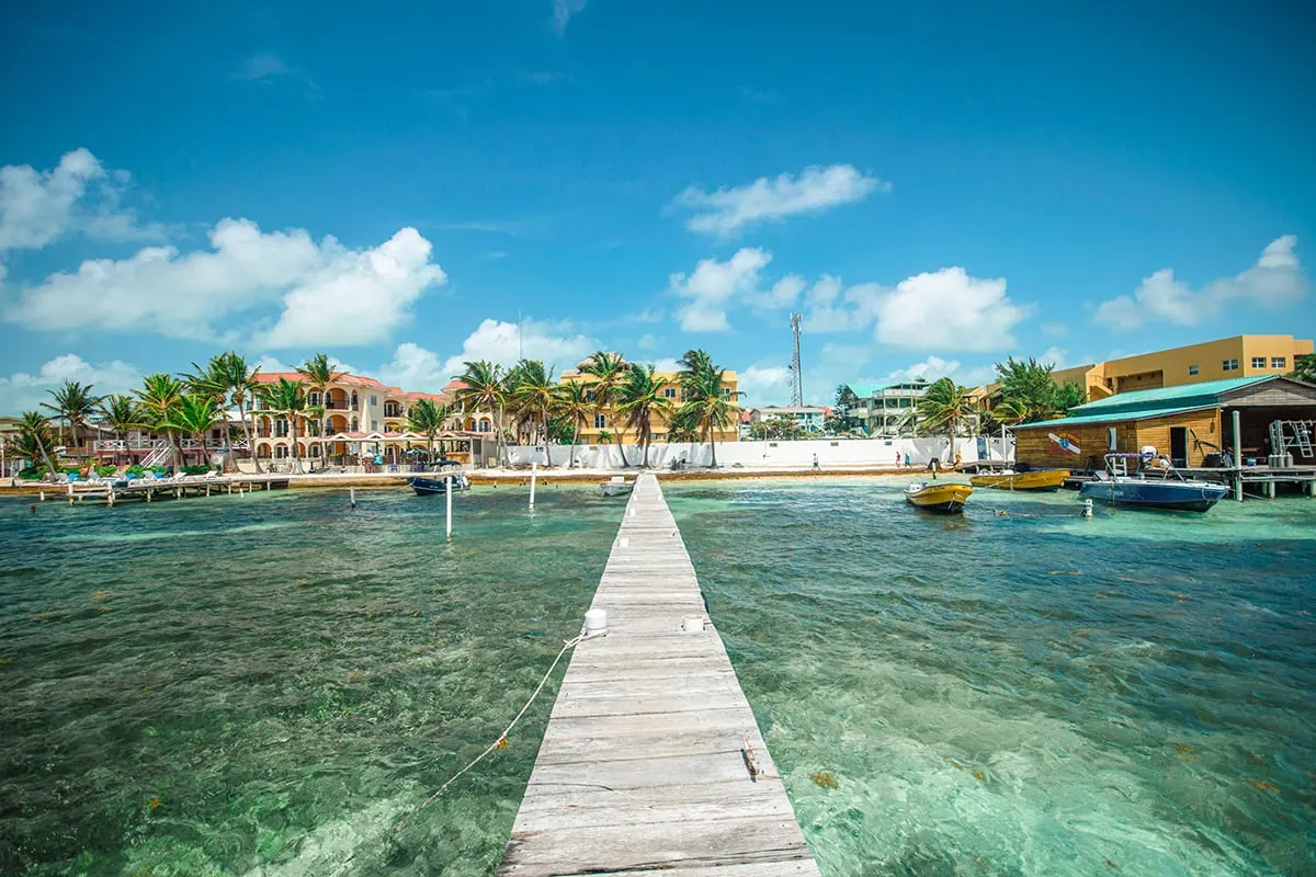 Best Beaches In Ambergris Caye For Swimming & Snorkeling 65 Standing on the end of a pier in Ambergris Caye looking back towards the shore.