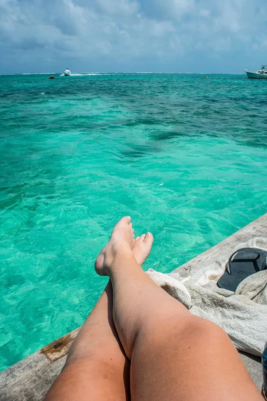 Best Beaches In Ambergris Caye For Swimming & Snorkeling 69 Tasha Amy sitting on the pier in Ambergris Caye after going for a swim.