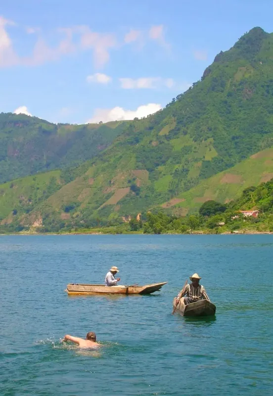 two local fisherman out on Lake Atitlan with a swimmer between them