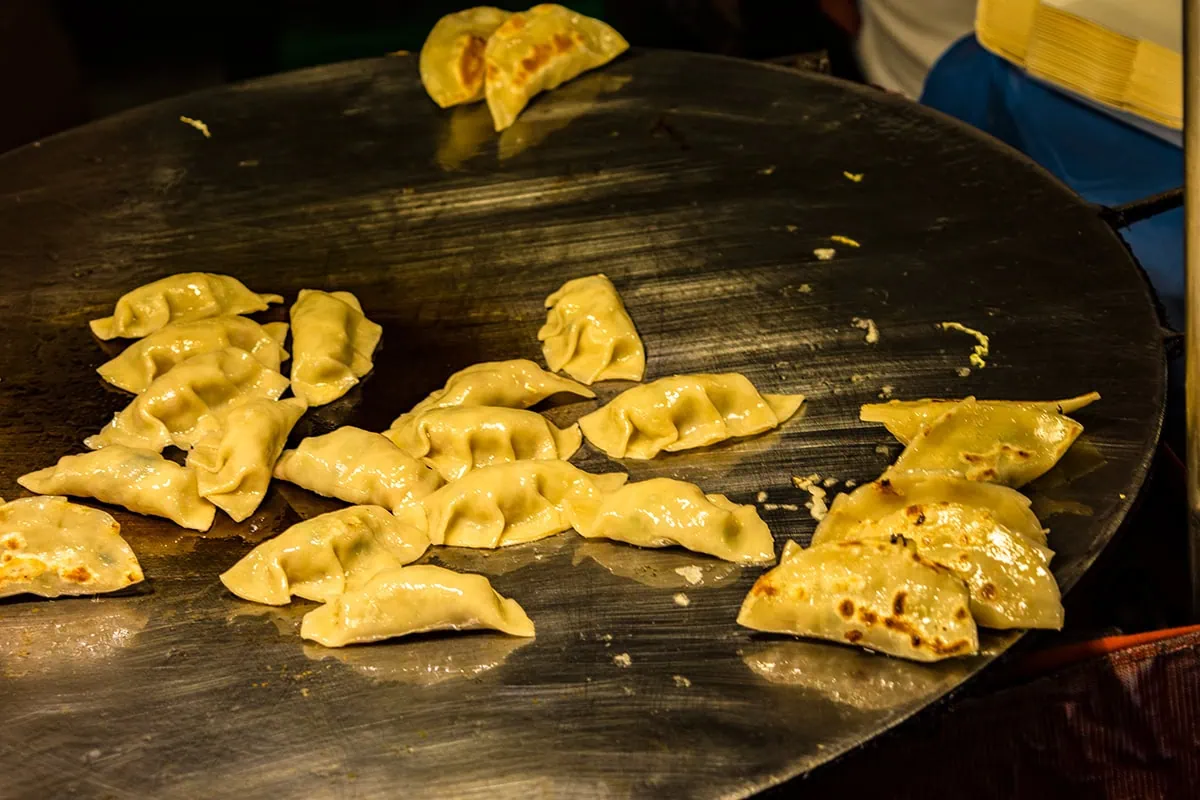 Freshly cooked dumplings on a hot griddle ready to be served at the Sunday Night Walking Street in Chiang Mai, Thailand