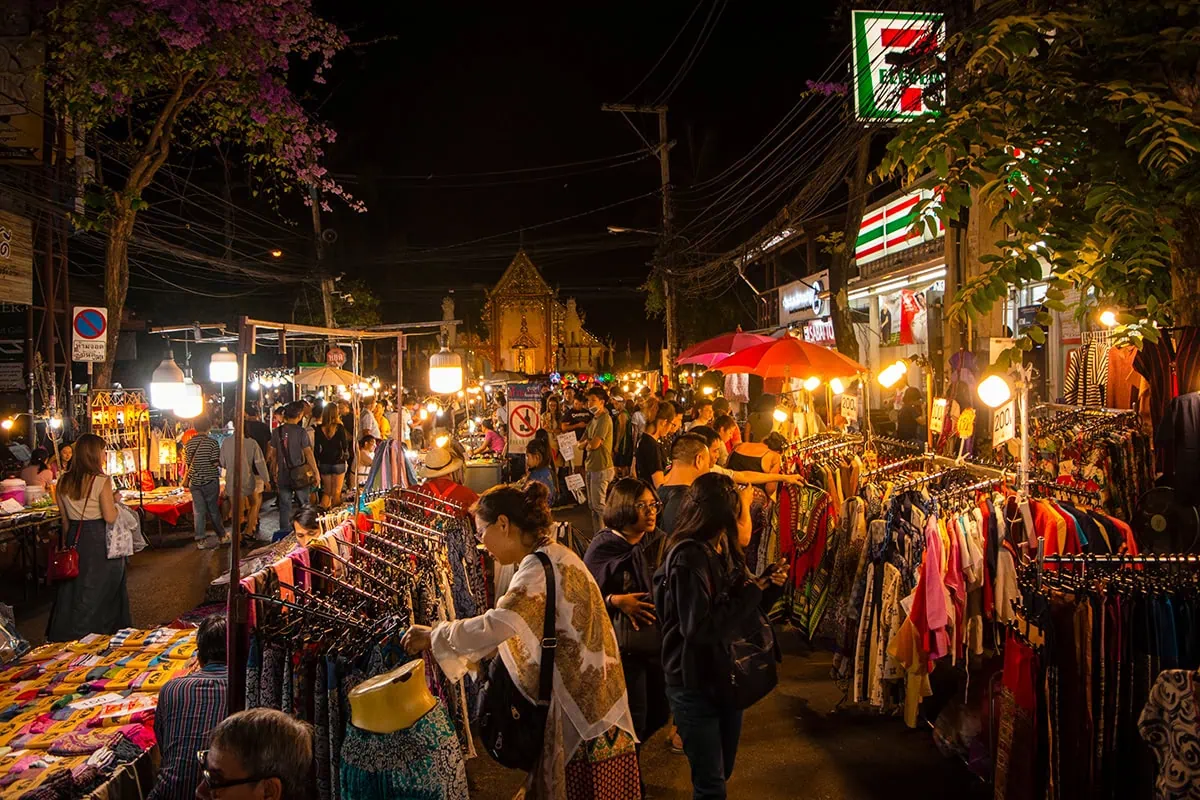 people shopping the clothing racks in the evening at the Chiang Mai Sunday night market