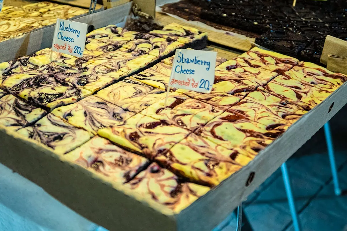 Trays of blueberry and strawberry cheesecake brownies for sale at the Sunday market in Chiang Mai.