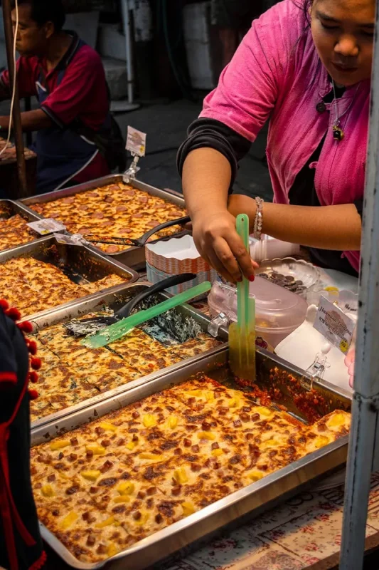 various types of lasagna dishes, being prepared at the Sunday Night Market in Chiang Mai.