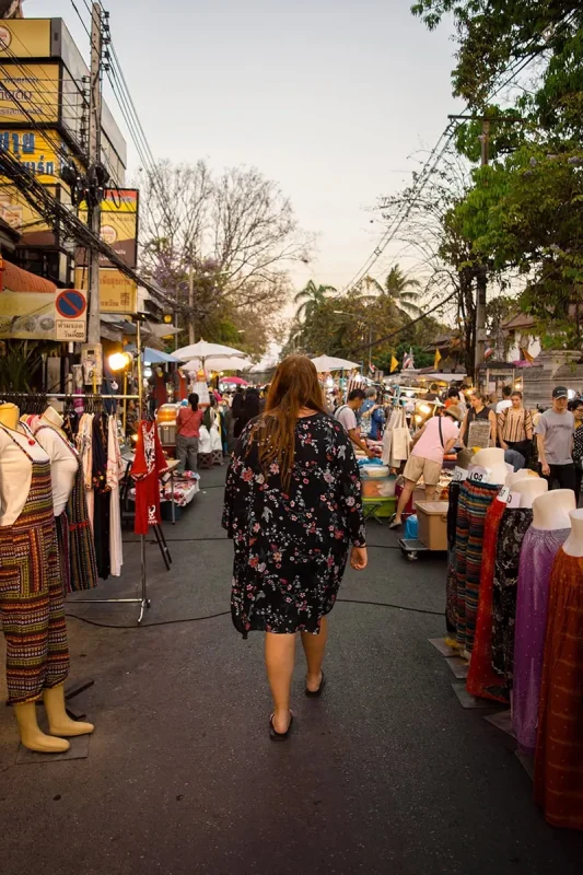 Tasha Amy walking through a clothing area at the Sunday Market in Chiang Mai.