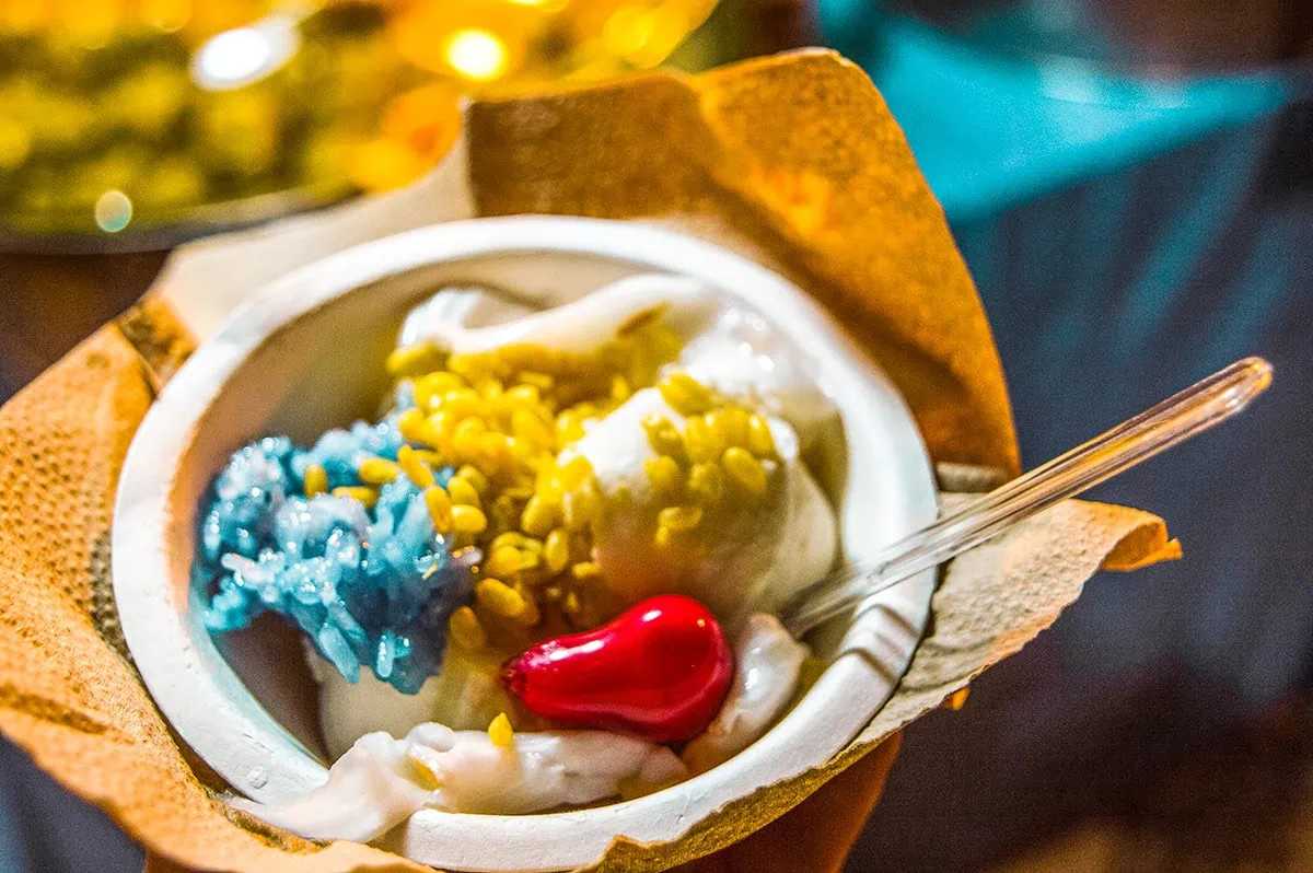 coconut ice cream with a red fruit, peanuts, and purple rice from the Chiang Mai Sunday Night Market in Thailand