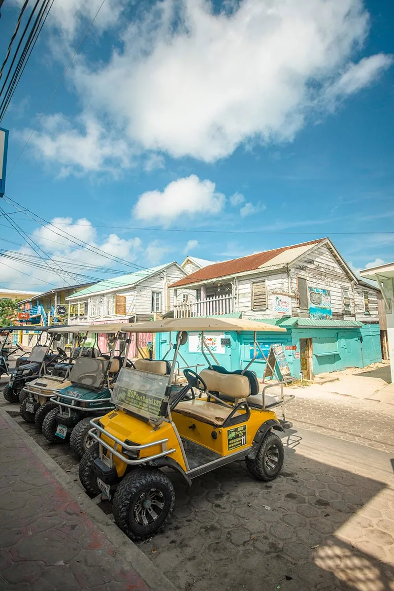 Honduras vs Belize: Which Is Better for Travelers? 60 golf carts lined up on the street in san pedro ambergris caye in belize