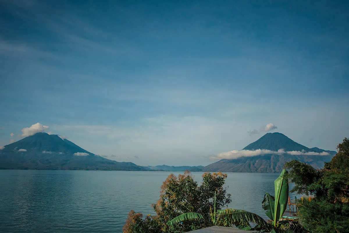 How To Get Around Lake Atitlan: Lanchas, Prices & Tips 18 the view over Lake Atitlan to two volcanos from Santa Cruz la Laguna