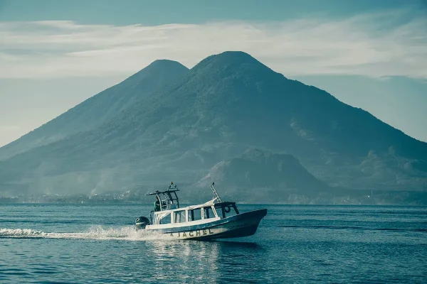 how to travel around Lake Atitlan by boat with a volcano behind