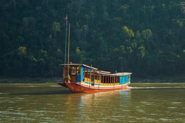 slow boat to Laos floating on mekong river with jungle behind