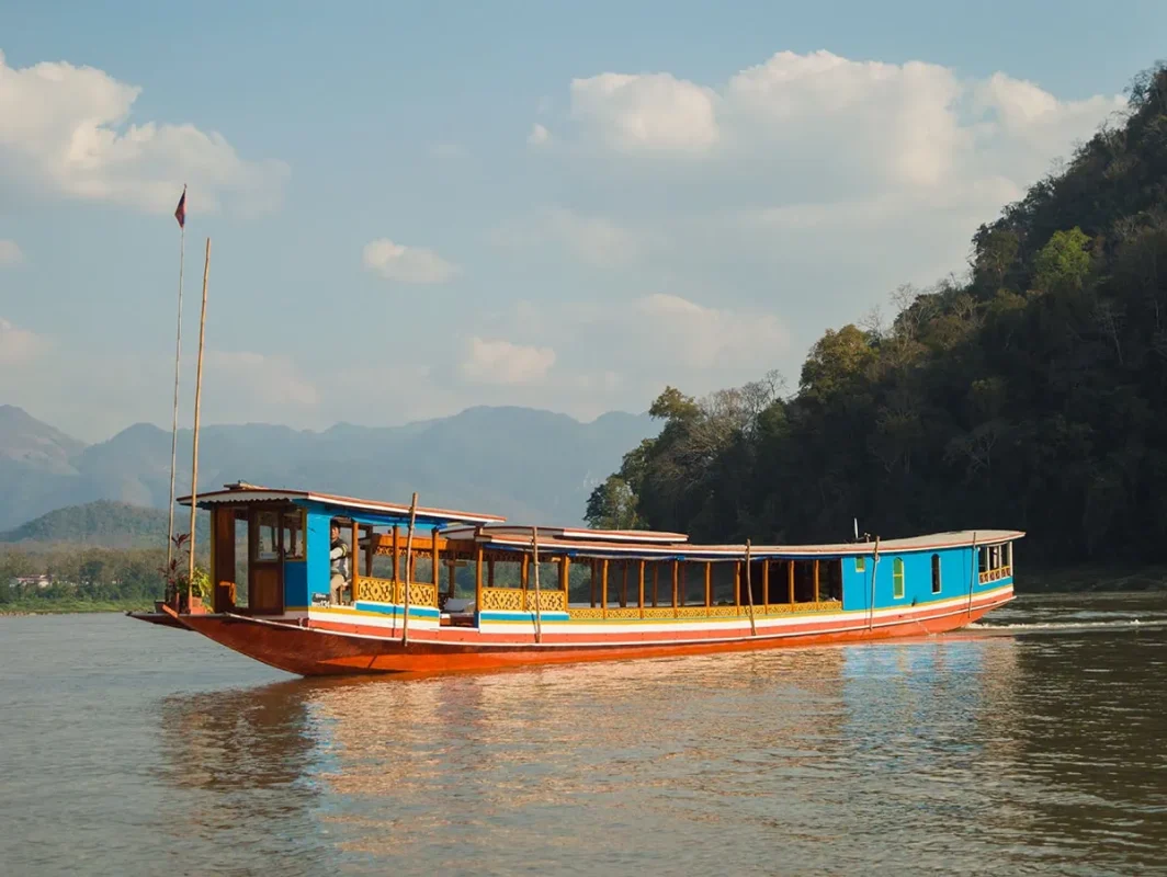 Slow Boat Laos: My Honest Guide After Doing It Twice (2026) 33 An empty slow boat to Laos floating on the Mekong River somewhere between Huay Xai to Luang Prabang